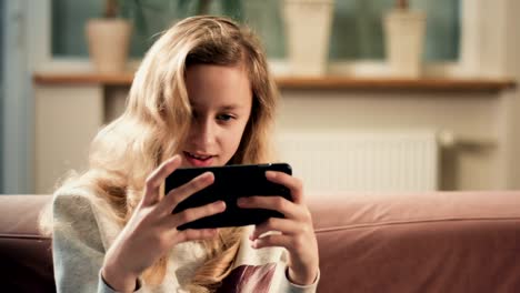 Blond-young-girl-focus-on-smartphone-screen.-New-mobile-game-app