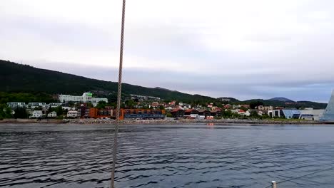 View-from-yacht-sailing-along-Norwagian-town-with-beautiful-houses-and-modern-buildings