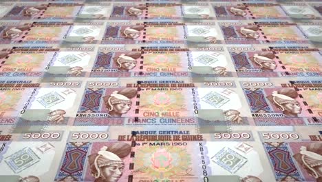 Banknotes-of-five-thousand-guinean-francs-rolling,-cash-money,-loop