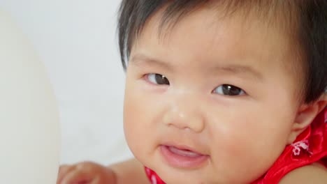 Cute-asian-little-baby-girl-having-fun-to-try-to-catch-and-play-with-balloon-in-slow-motion-shot