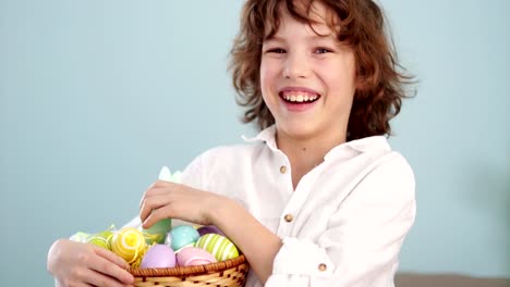 Klaus-ap-portrait-of-a-curly-red-haired-boy-with-a-basket-of-Easter-eggs-in-his-hands.-Happy-easter