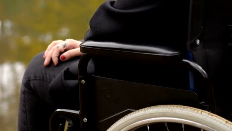 disability,-sadness,-loneliness---hands-of-a-wheelchair-woman-contemplating-the-lake