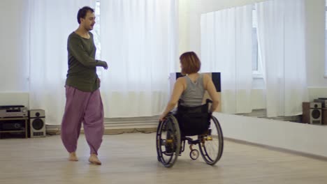 Expressive-Man-Dancing-with-Paraplegic-Woman-in-Wheelchair-in-Studio