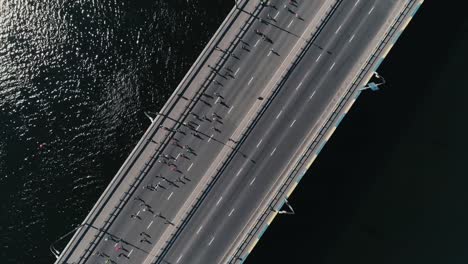 4K-Aerial-drone-fooage.-Marathon-running-on-the-bridge.-Camera-rotate-top-view