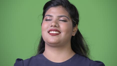 Young-overweight-beautiful-Indian-businesswoman-against-green-background