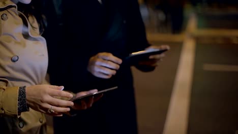 Young-man-and-woman-using-digital-tablets-on-street