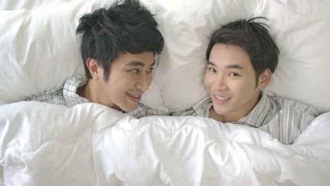 Gay-couple-in-bed-making-love-under-white-blanket.-People-with-gay,-homosexual,-relationship-concept.