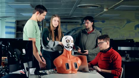 Team-of-engineers-are-having-a-discussion-over-a-human-like-robot