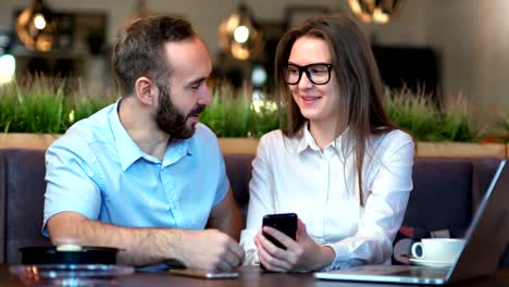 Gente-de-negocios-retrato-discutiendo-aplicación-de-desarrollo-usando-smartphone-con-reunión-informal