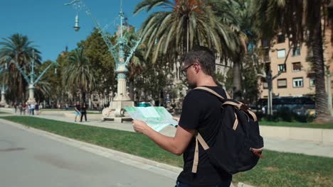 El-viajero-masculino-está-paseando-solo-en-la-calle-de-la-ciudad,-viendo-mapa-de-papel