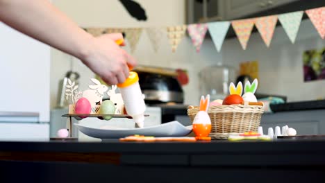 Frau-dekoriert-Cookies-in-Osterinnenraum