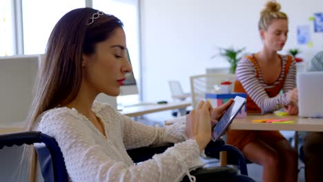 Side-view-of-young-Caucasian-disabled-female-working-on-digital-tablet-in-modern-office-4k