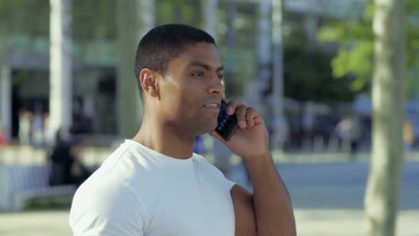 Lächelnde-afroamerikanische-Sportler-reden-auf-Smartphone.