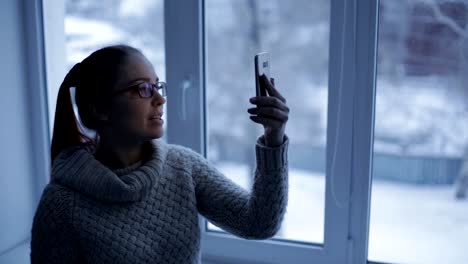 Kaukasische-Frau-nutzt-Smartphone,-Telefon-Bildschirm-spiegelt-sich-in-Glas-sozialen-Netzwerk,-Technik,-Kommunikationskonzept.