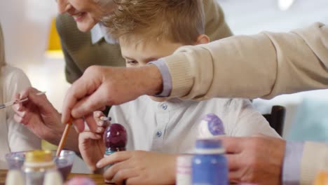 Family-Talking-and-Smiling-while-Painting-Eggs