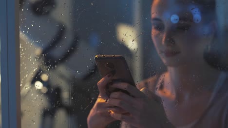 Lächelnde-Mädchen,-die-nachts-mit-ihrem-Telefon-textsicher-ist