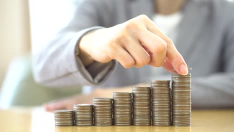 Close-up-Of-woman-Hand-Put-Coins-To-Stack-Of-Coins