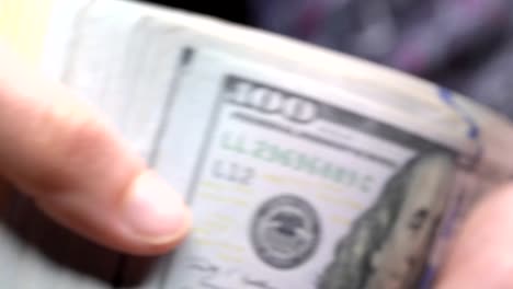 closeup-hand-shuffles-new-hundred-dollar-bills