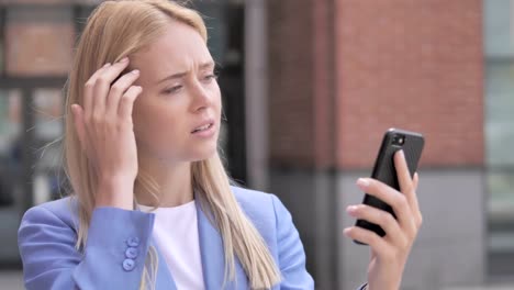 Outdoor-Young-Businesswoman-reacting-to-Loss-on-Smartphone