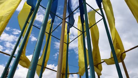 Ukrainische-Flaggen-flattern-im-Wind-gegen-einen-blauen-Himmel.-Helle-gesättigte-gelb-blaue-Farben.