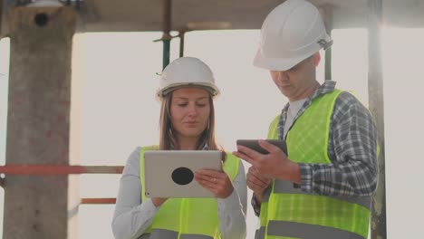 Supervisor-de-un-edificio-en-construcción-discutiendo-con-la-diseñadora-de-ingeniería-el-progreso-de-la-construcción-y-examina-un-plan-de-construcción