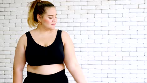 Overweight-young-woman-in-sportswear-exercising-with-dumbball-at-home