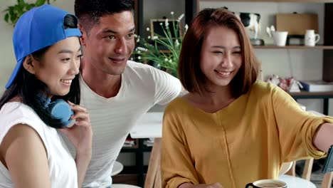 Three-Friends-Making-Selfie-in-Café