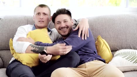 Pareja-gay-relajándose-en-el-sofá.-Disfruta-viendo-la-televisión,-bistas.