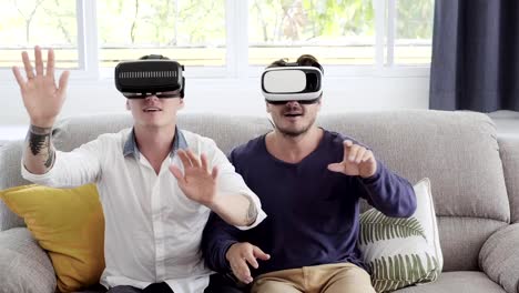 Schwules-Paar-entspannen-auf-der-Couch-mit-Virtual-Reality-Gerät.-Blick-in-die-VR-Welt.