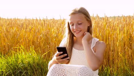 happy-young-girl-with-smartphone-on-cereal-field