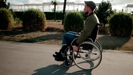 Independent-male-disabled-guy-is-moving-sitting-in-wheelchair-over-street