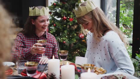 Schwules-weibliches-Paar-sitzt-um-Tisch-für-Weihnachten-Abendessen-zusammen