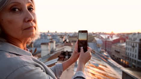 Grey-haired-Woman-Making-Photos-on-Roof