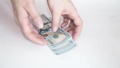 Female-hand-on-white-background-throws-money-on-table