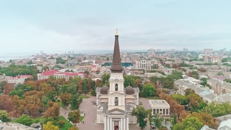 Filmische-Luftaufnahme-der-Verklärung-Kathedrale-in-Odessa-und-Stadtzentrum-an-bewölkten-Tag.