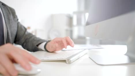 Close-up-of-man's-hands-using-desktop-computer