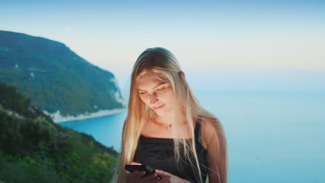 Mujer-usando-el-teléfono-inteligente-con-el-océano-en-el-fondo