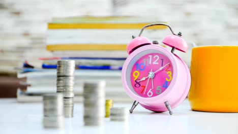 Time-Lapse-of-clock-and-stacking-coin-with-movement-focus-on-clock