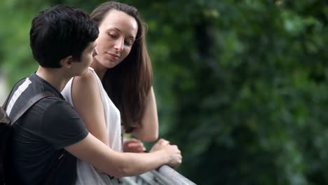 Lesbian-correct-hair-of-her-girlfriend-on-a-bridge