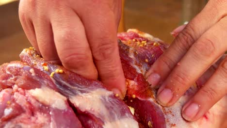 Hands-of-the-cook-placed-garlic-into-the-lamb