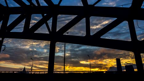 Zeitraffer-Video-eines-Teils-der-Stahlbrücke-mit-Sonnenuntergang-und-schnell-ziehenden-Wolken-im-Hintergrund