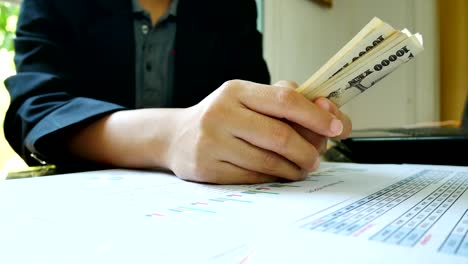 Close---up-working-woman--hand-count-money-with--financial-report-in-bussiness-and-financial-concept.