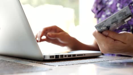 Mujer-con-laptop-y-tarjeta-de-crédito-en-la-cafetería.