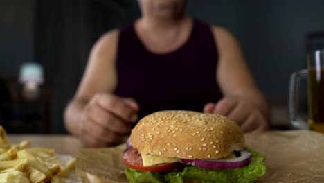 Übergewichtige-Menschen-beißen-große-Burger-Stück,-übermäßiges-Essen-in-der-Nacht,-Adipositas