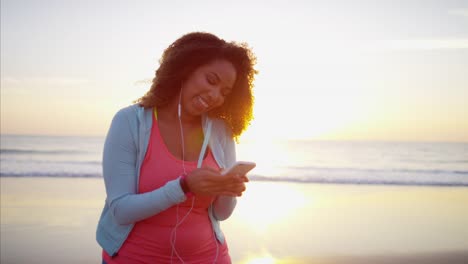 Étnica-mujer-texto-con-teléfono-inteligente-al-atardecer