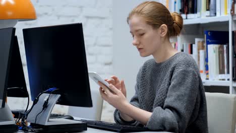 Mujer-pelirroja-navegar-por-Internet-en-línea-en-Smartphone