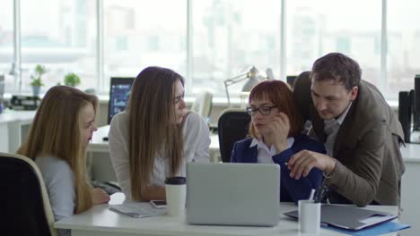 Female-Business-Leader-Talking-to-Young-Employees-in-Office