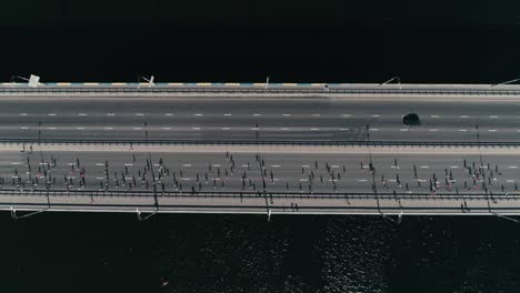 Fooage-aérea-drone-de-4K.-Cámara-lenta-maratón-en-el-puente.-Dolly-horizontal-tiro-vista-superior