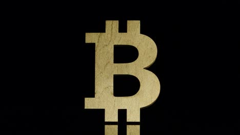 SLOW:-Golden-bitcoin-symbol-stands-and-falls-back-on-a-black-background