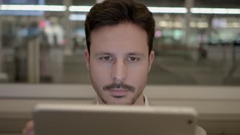 Caucasian-employee-working-online-and-mobile-at-train-station-with-digital-tablet